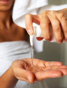 Mulher colocando nas mãos sabonete da ADCOS que possui vitamina C em sua fórmula