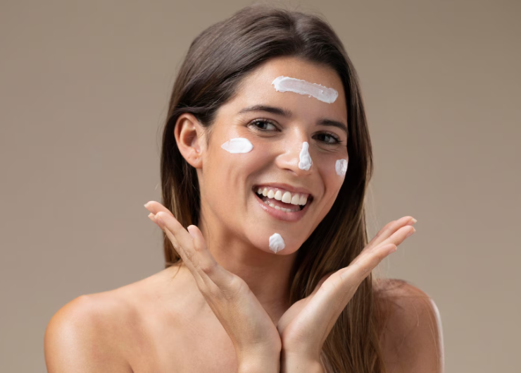 
Descrição (alt-text): Mulher aplicando protetor solar no rosto de forma uniforme, cobrindo testa e bochechas.