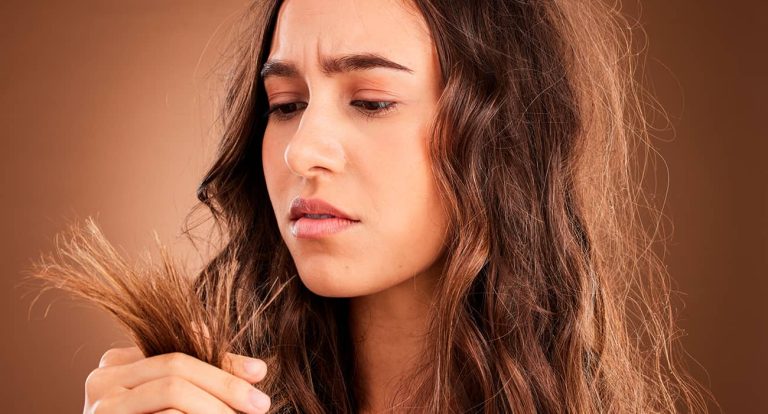 mulher olhando para as pontas do cabelo danificado