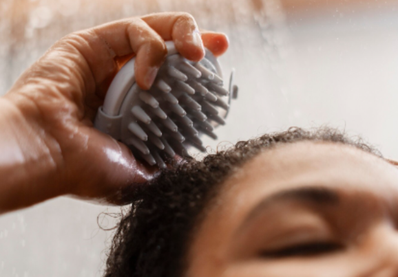 fios de cabelo sendo lavados no chuveiro após dia de praia para remover sal e cloro